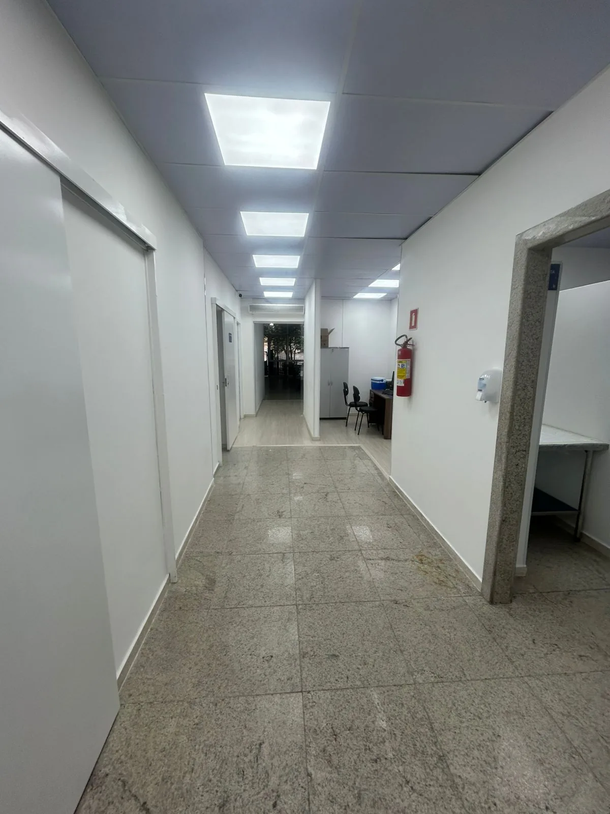 Corredor corporativo finalizado com piso de granito polido
