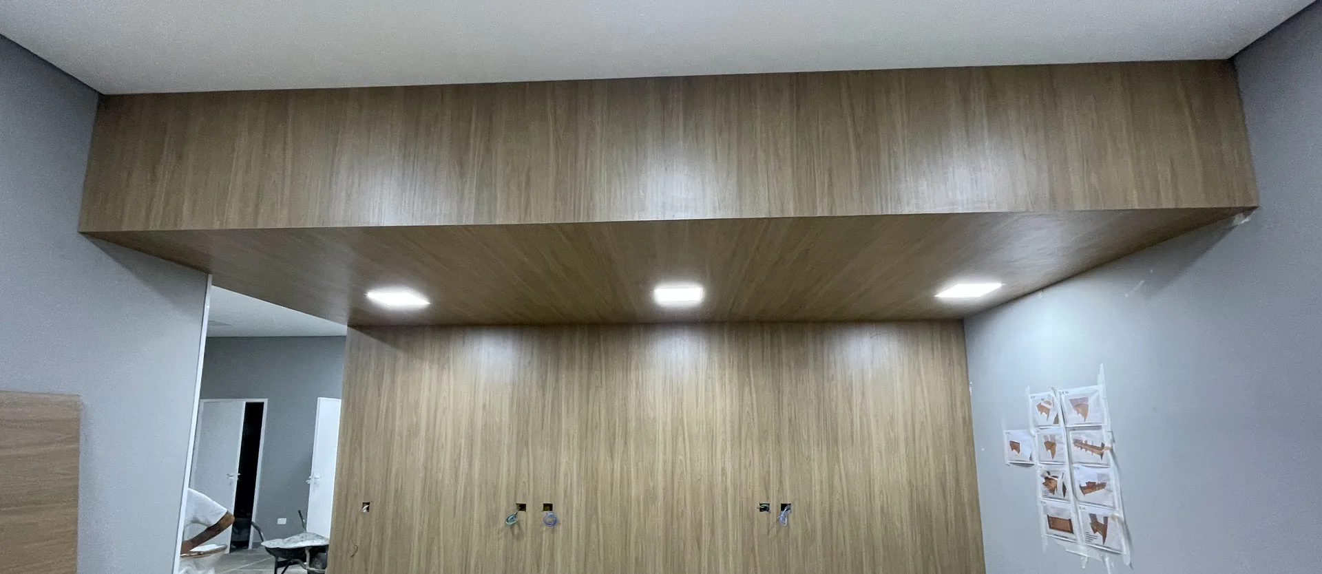 Parede de marcenaria com iluminação embutida, exemplo de acabamento entregue pela RAV em ambiente comercial