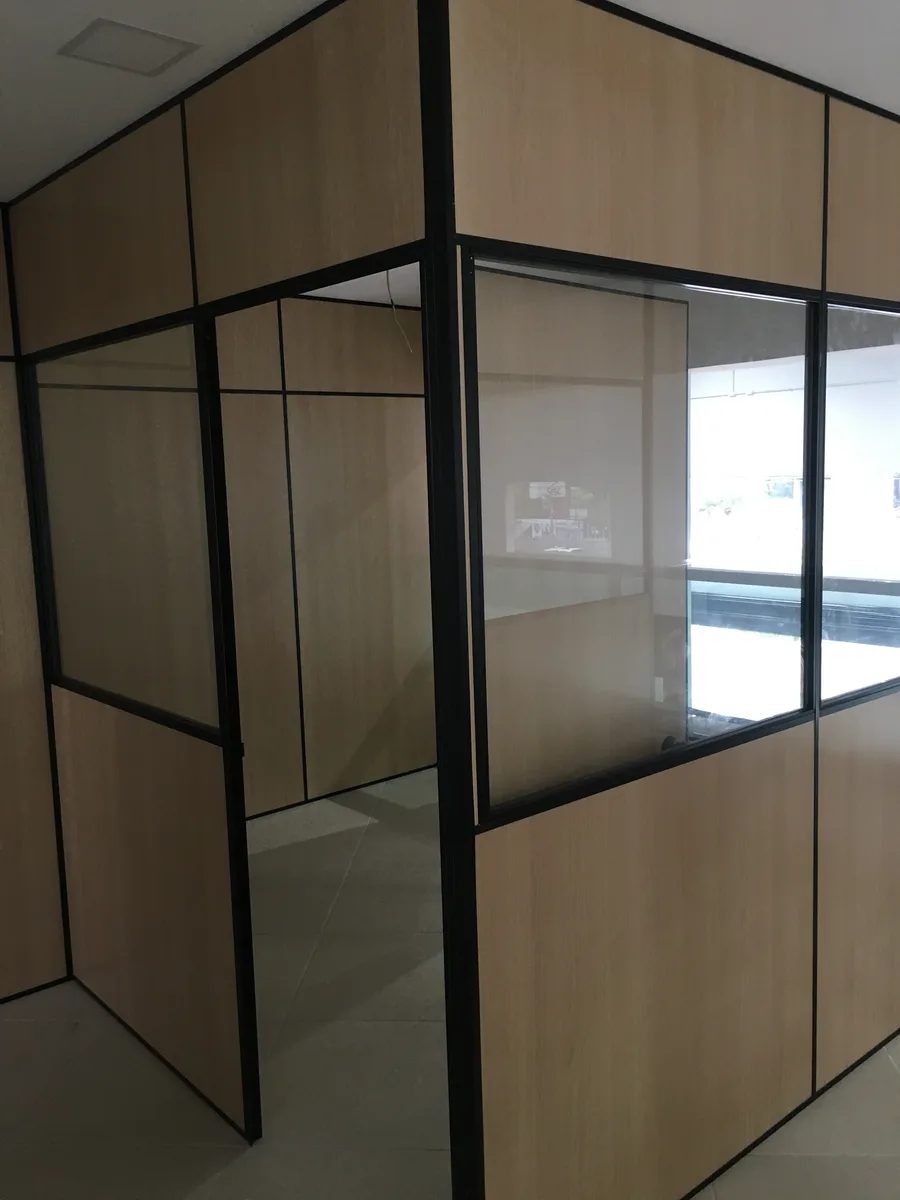 Sala corporativa finalizada com divisórias de vidro e madeira, entregue pela RAV
